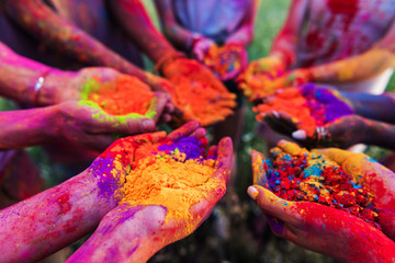 close-up partial view of young people holding colorful powder in hands at holi festival - obrazy, fototapety, plakaty