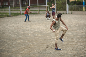 group of young multiethnic men playing baseball on court