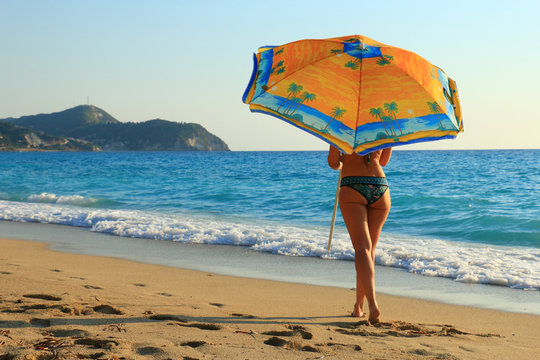 beautiful woman on tropical beach with umbrella