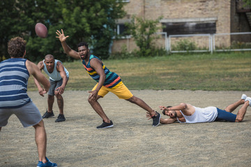 Obraz premium group of young multicultural men playing football on court