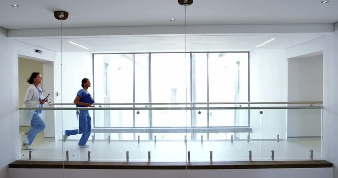 Doctor and nurse running in passageway of hospital 