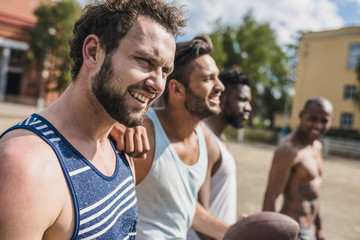 group of young multicultural male football players on court