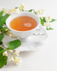 Cup of tea with jasmine flowers on a white table