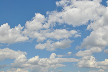 Background with a blue sky and white clouds. White fluffy clouds in the blue sky
