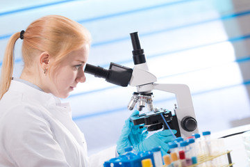Doctor woman working  a microscope. Female scientist looking through a microscope in lab. Student girl looking in a microscope, science laboratory concept