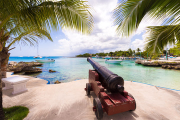 Ship cannon on the embankment of the city of Bayahibe, La Altagracia, Dominican Republic. Copy space for text. - obrazy, fototapety, plakaty