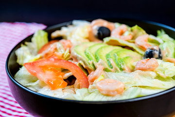 Delicious fresh salad with tomatoes, lettuce, eggplant, zucchini, cheese, parma ham and olive oil.