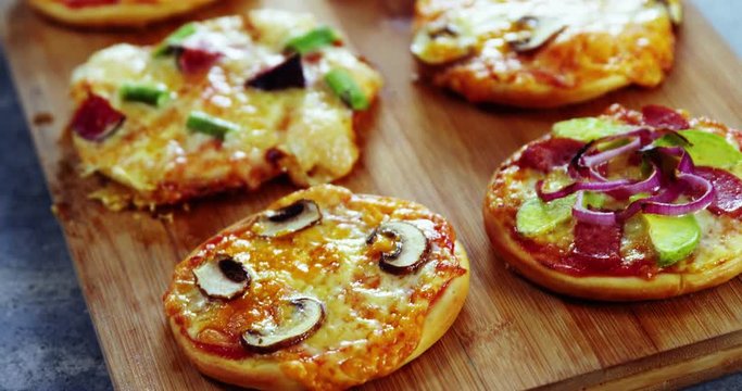 Various pizzas on wooden board
