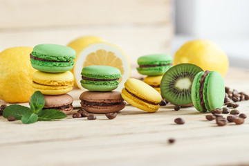 Green and yellow french macarons with kiwi, lemon and mint decorations