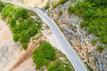 Fototapeta na wymiar Top view of an empty curved asphalt road in the mountains
