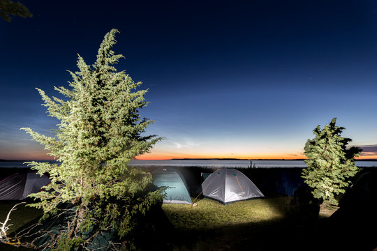 Twilight over sea with many camped tents