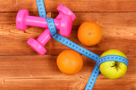 dieting food concept, dumbbells weight with measuring tape, fruit