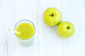 Apple juice on a white table. Top view. Copy space. The concept is healthy food, vegan, diet, weight loss.