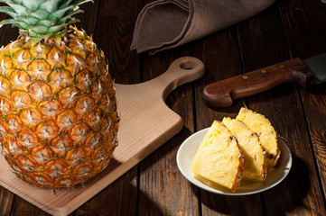 slices of a pineapple on dark wooden background