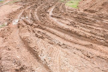 Dirty broken rural road with deep tire tracks.