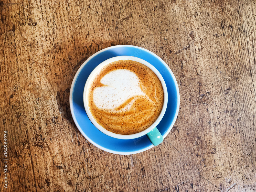 Aufkleber coffee cup with heart pattern in coffee shop on wooden table with vintage style effect, close up wit