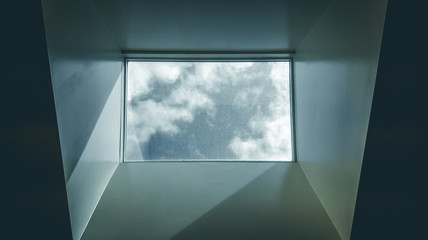 Modern interior skylight showing grey sky and misty clouds. Black and white skylight in modern office building. Abstract, artistic image of sky and clouds - 164966970