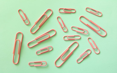 Pink paper clips on blue backgroung