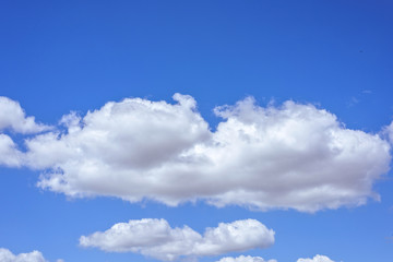Naklejka na ściany i meble Beautiful big white clouds over blue sky, sunny summer day, close up