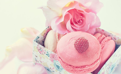 Macarons with raspberries, marshmallows on the background of beautiful flowers roses. Dessert close-up. copy space