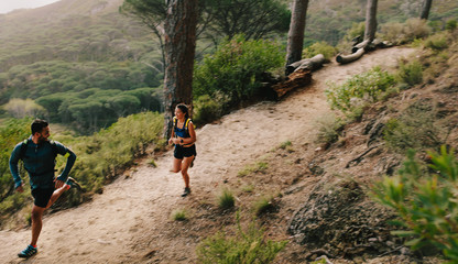 Naklejka premium Couple of fit athletes running on mountain path