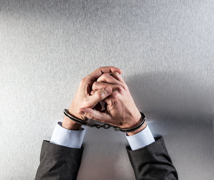 businessman hands bothered with handcuffs suffering for suspicious business