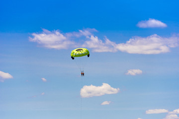 Parasailing against a background of clouds and blue sky. Copy space for text.