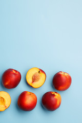 A few ripe nectarines on a blue background