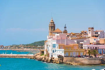 Foto op Canvas View of the historical center and the ñhurch of Sant Bartomeu and Santa Tecla in Sitges, Barcelona, Catalunya, Spain. Copy space for text. Isolated on blue background. © ggfoto