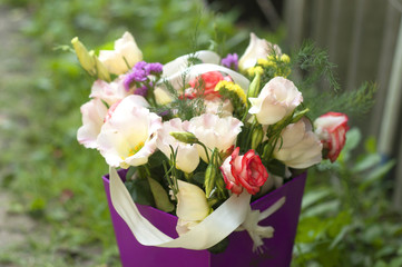 Bouquet of flowers in a purple cardboard box. A beautiful bouquet of flowers in garden