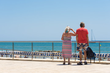 Fototapeta premium Mature married couple on the waterfront in the Sitges, Barcelona, Catalunya, Spain. Copy space for text.