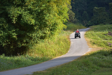 Woman driving off-road with quad bike or ATV