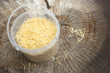 Homemade noodles in a plastic box isolated on wooden background