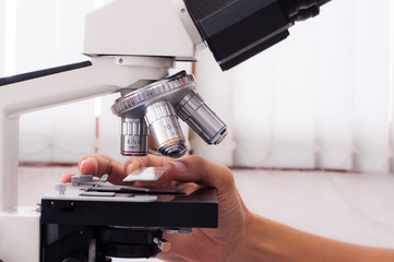 Doctor hand with microscope in laboratory room. Scientific research