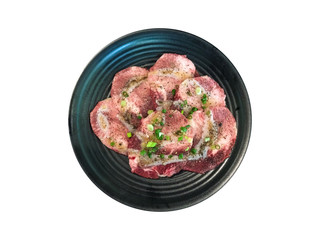 Isolated sliced beef on black plate.