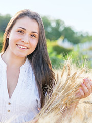 Beautiful young sexy woman in golden wheat field at summer sunny day. Portrait of pretty smiling girl outdoor