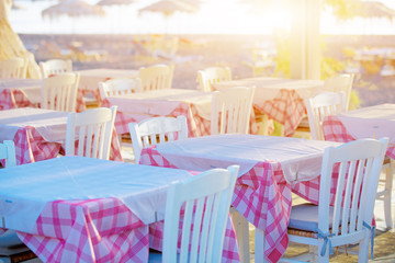 Tables and chairs in a street restaurant in Kamari on Santorini