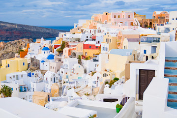 Fototapeta premium Oia miasteczko na Santorini wyspie, Grecja. Tradycyjne i słynne białe i różowe domy w słoneczny dzień