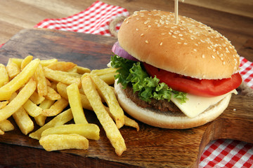 fresh tasty burger and french fries on wooden table