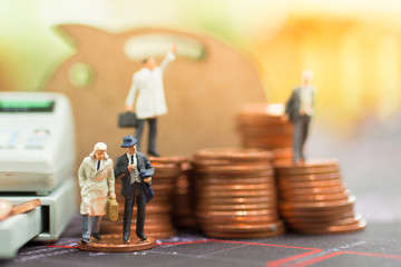 Fototapeta na wymiar Miniature people: Small figure standing on stack of coin. Using as money and financial concept.