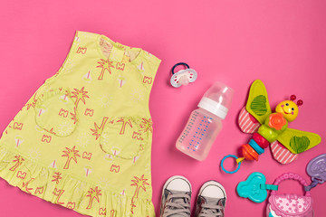 Baby clothes and accessories on pink background. Top view
