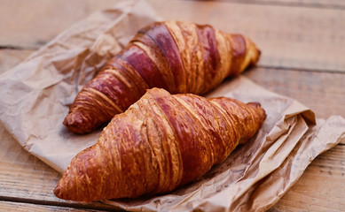 Delicious crispy croissant on a wooden desk.