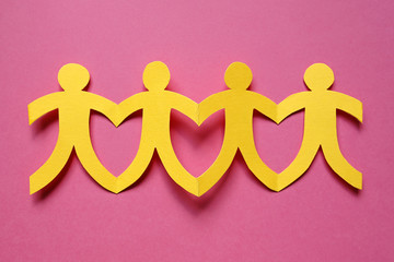 teamwork, yellow paper people on pink background