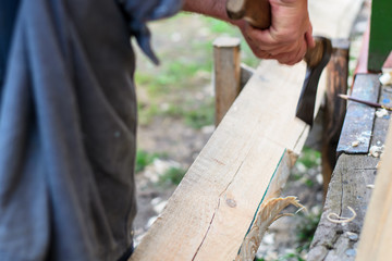 A man hacking a wooden board with an ax