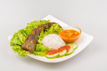 Isolated catfish fried ala Indonesia with condiments, Indonesian food