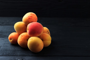 Apricots on black wooden background