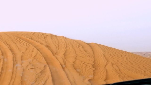 4x4 off road land vehicle taking tourists on desert dune bashing safari in Dubai, UAE