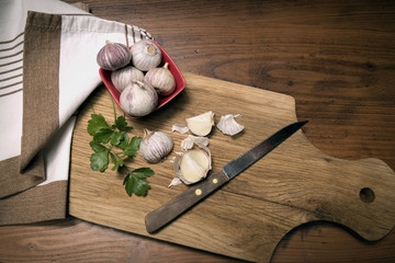 Garlic in red bowl on the chopping block.