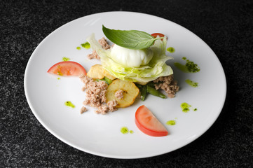 Mix salad with egg poached and tuna on a white plate