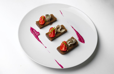 Bruschetta with sprat with cherry tomato and beet mousse